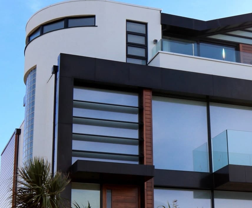 A modern white and dark commercial building against a blue sky